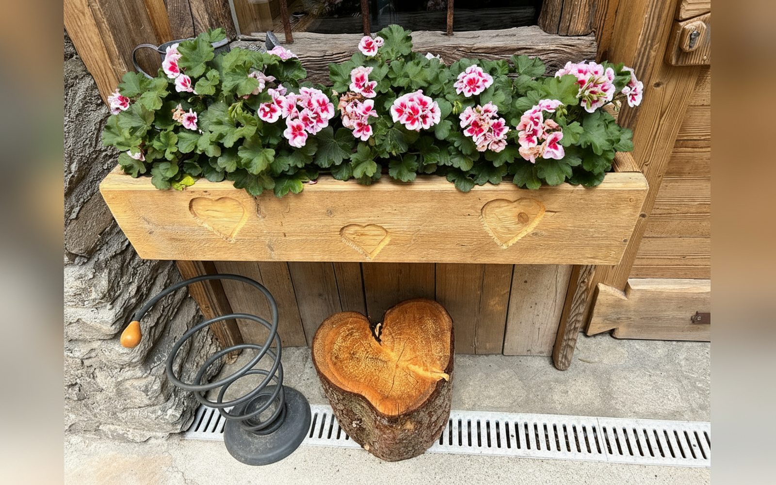Fioriera in legno a cuori davanti a Petit Abri