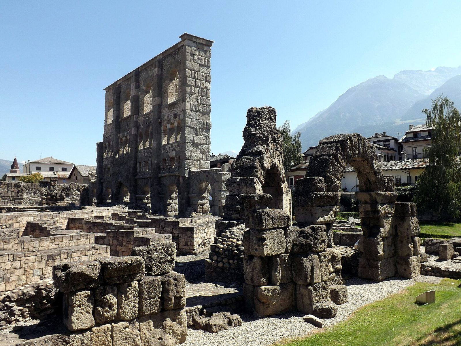 La facciata meridionale del Teatro romano di Aosta con i resti delle arcate in primo piano e le montagne sullo sfondo